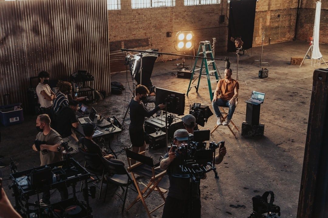 Filmteam arbeider med kamera, lys og monitor i et industrilokale